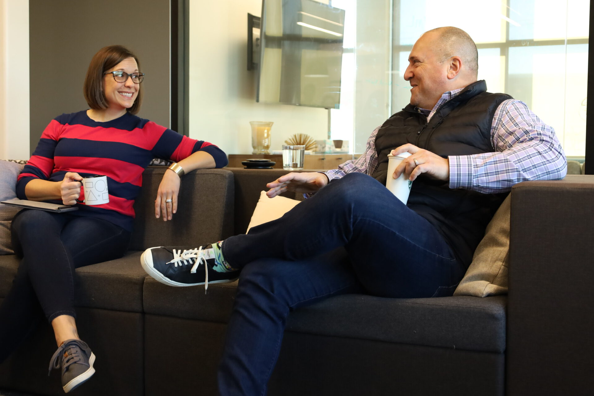 Lacey Lavies sits with Jeremy Reymer discuss founding DriverReach on a couch at Innovatemap