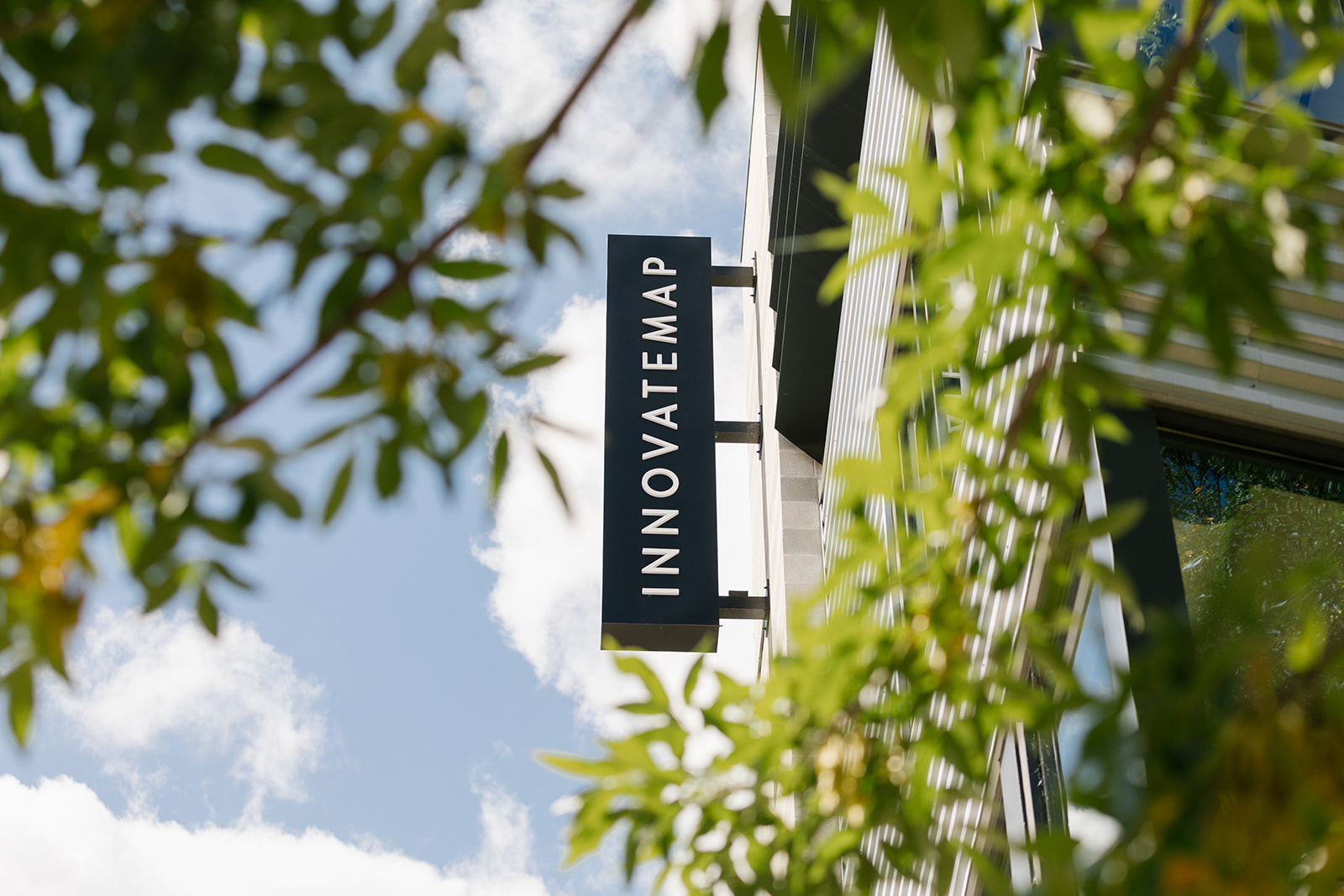 Innovatemap company sign with leaves and blue sky in Broad Ripple.